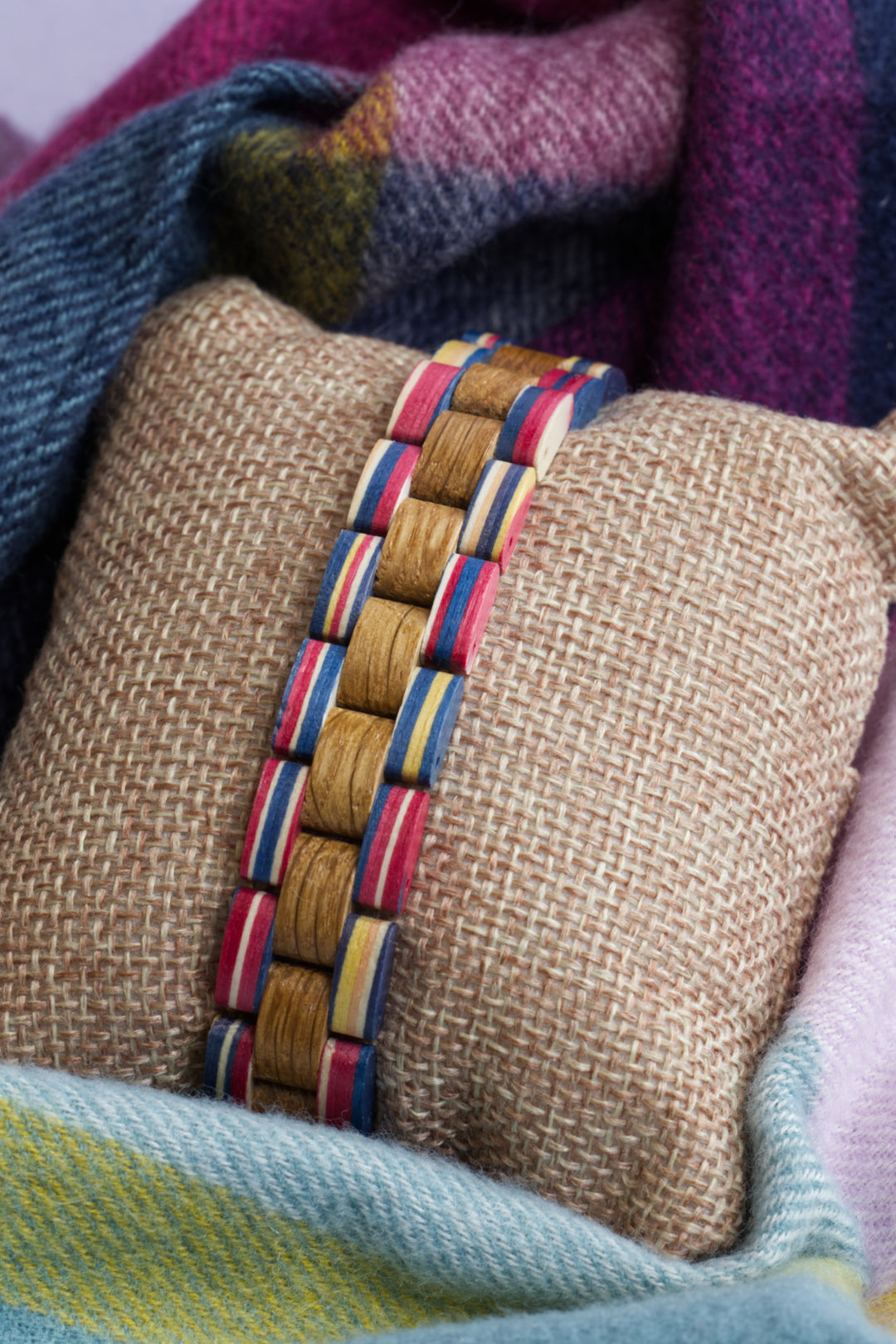 Amalfi colourful wooden bracelet on a cushion with a check blanket - The Wood Look