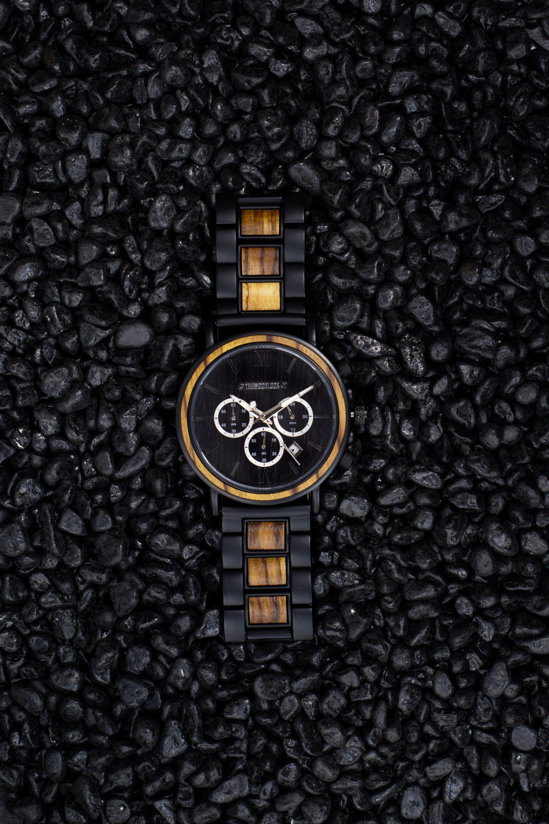Boston zebrawood chronograph watch from above on black stones - The Wood Look