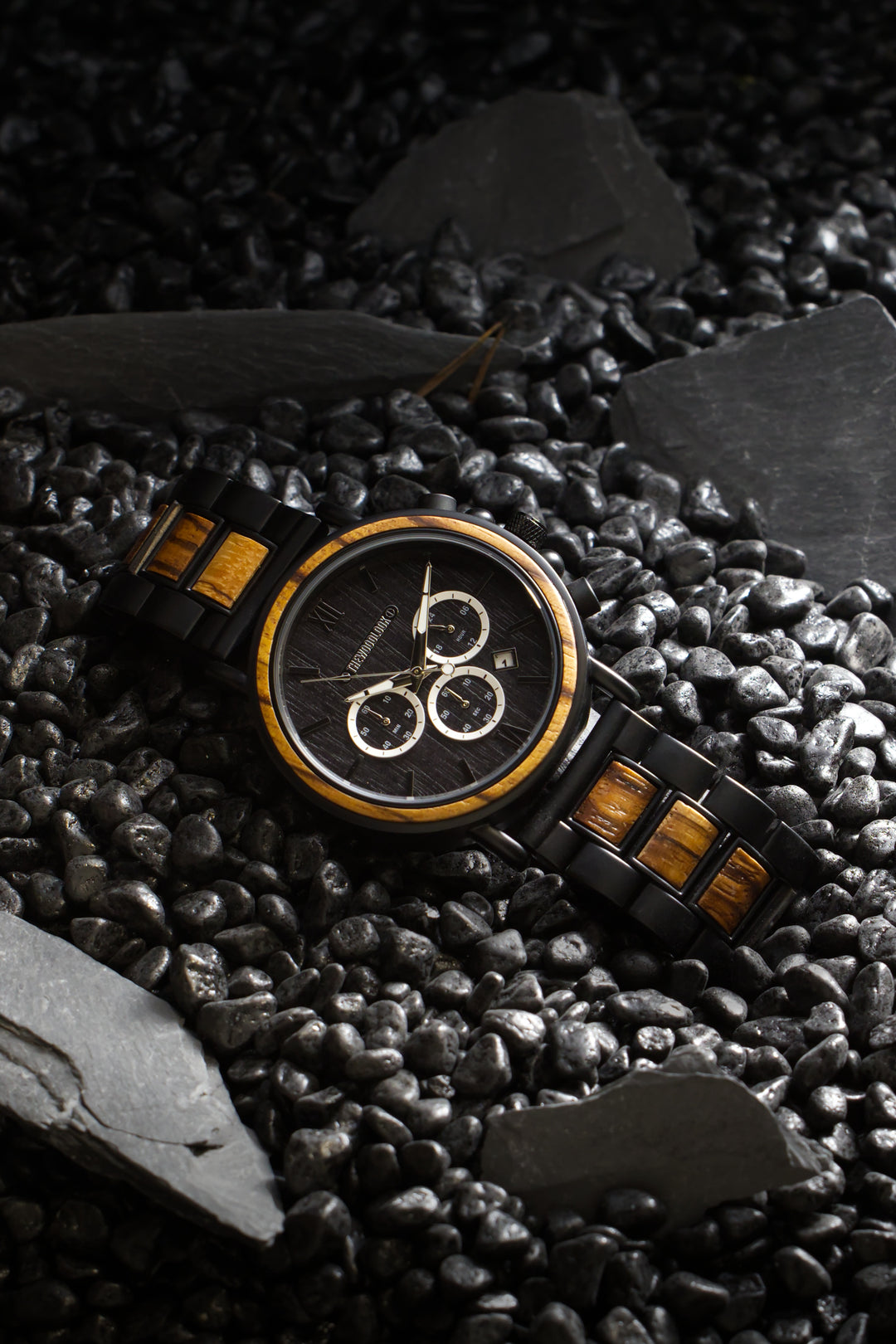 Boston zebrawood and black steel watch among black stones and slate - The Wood Look