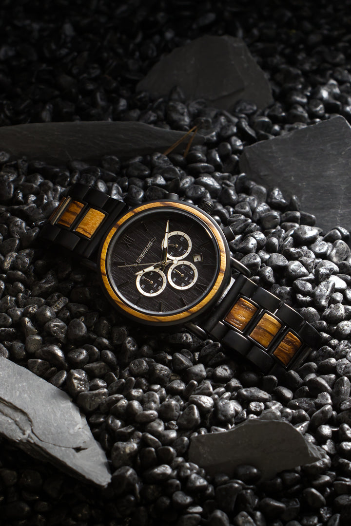 Boston zebrawood and black steel watch among black stones and slate - The Wood Look