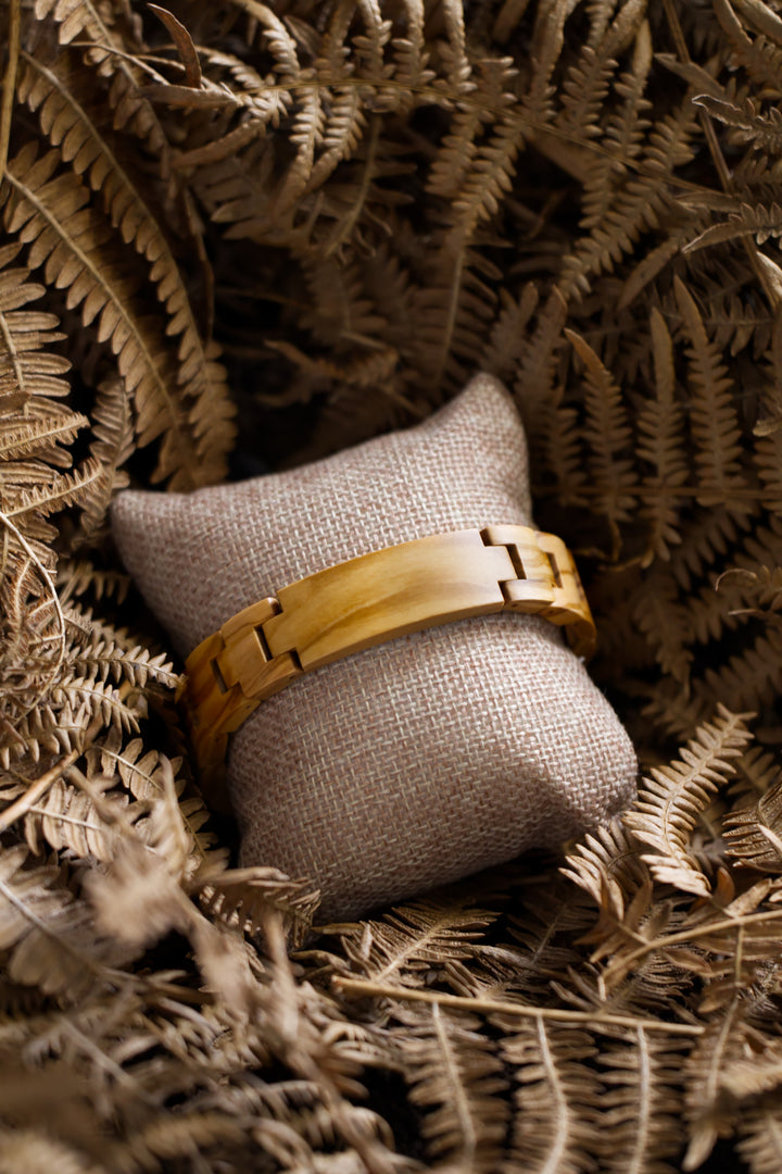 Carmel olive wood bracelet on a cushion among dried ferns - The Wood Look