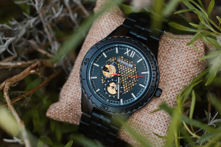 Detroit ebony mechanical watch on a hessian cushion in long grass - The Wood Look