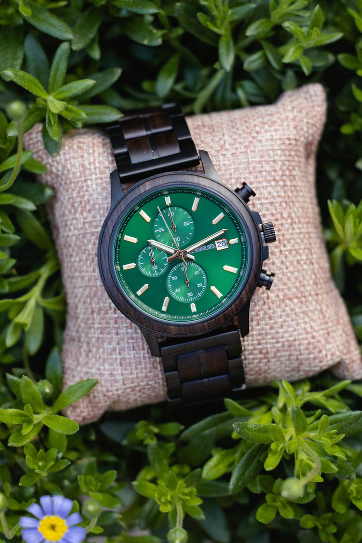 Gothenburg green dial wooden chronograph watch on a hessian cushion with a blue flower - The Wood Look