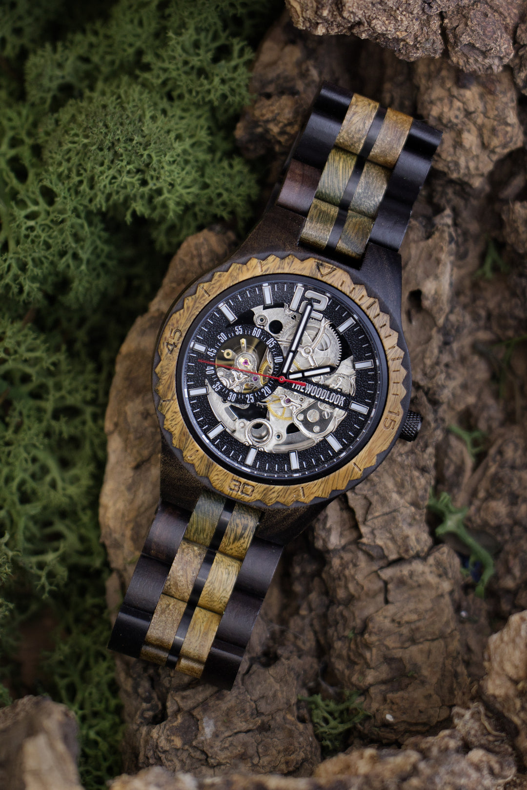 Havana mechanical watch in ebony and green sandalwood with a skeleton dial, on bark and moss - The Wood Look