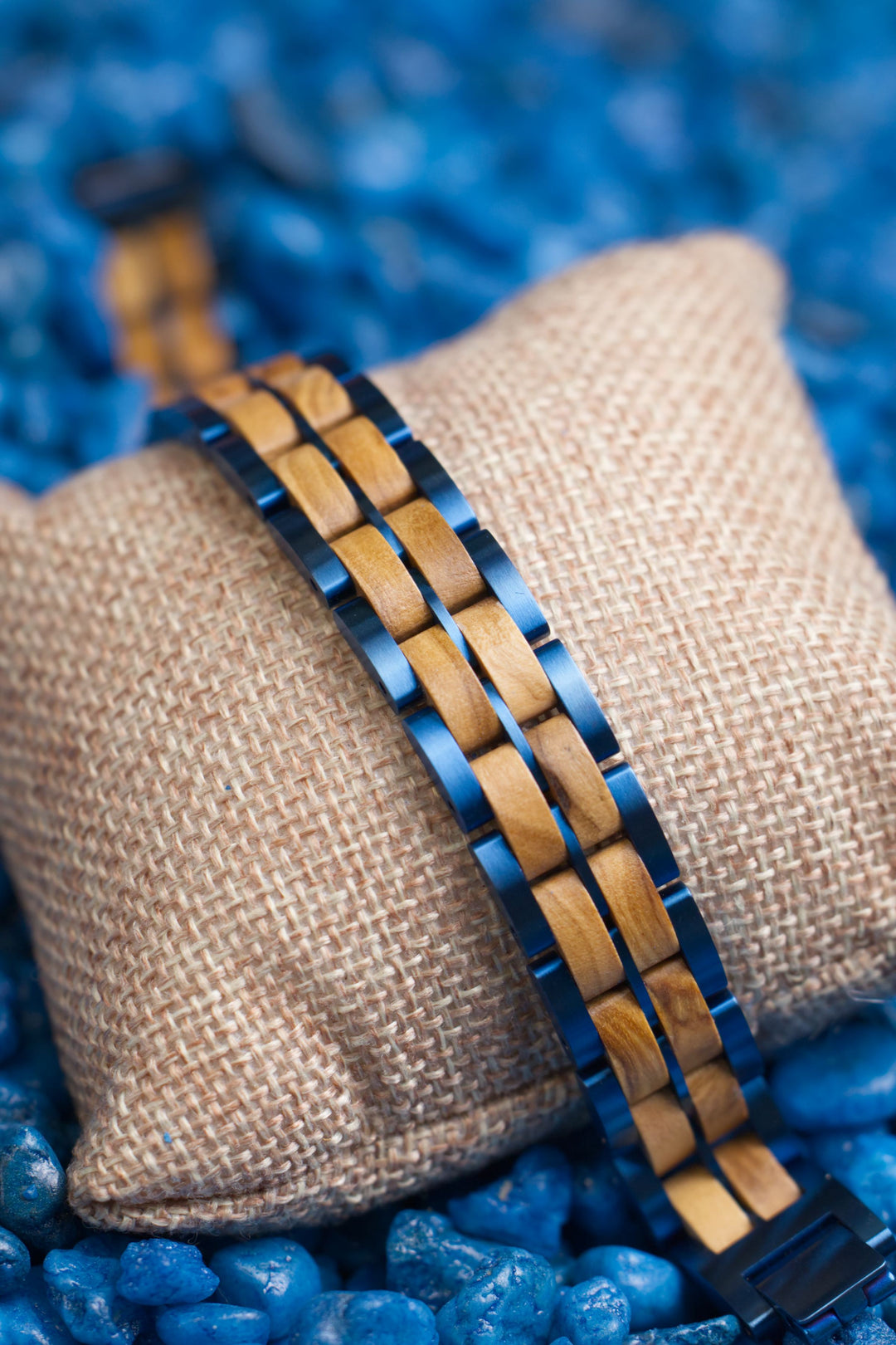 Jodhpur olive wood and blue steel bracelet on a cushion over blue stones - The Wood Look