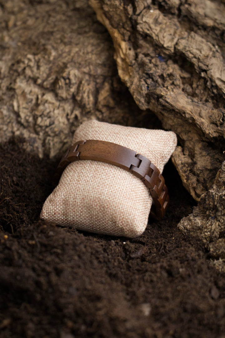 Juglans walnut wooden bracelet on a cushion beneath bark - The Wood Look