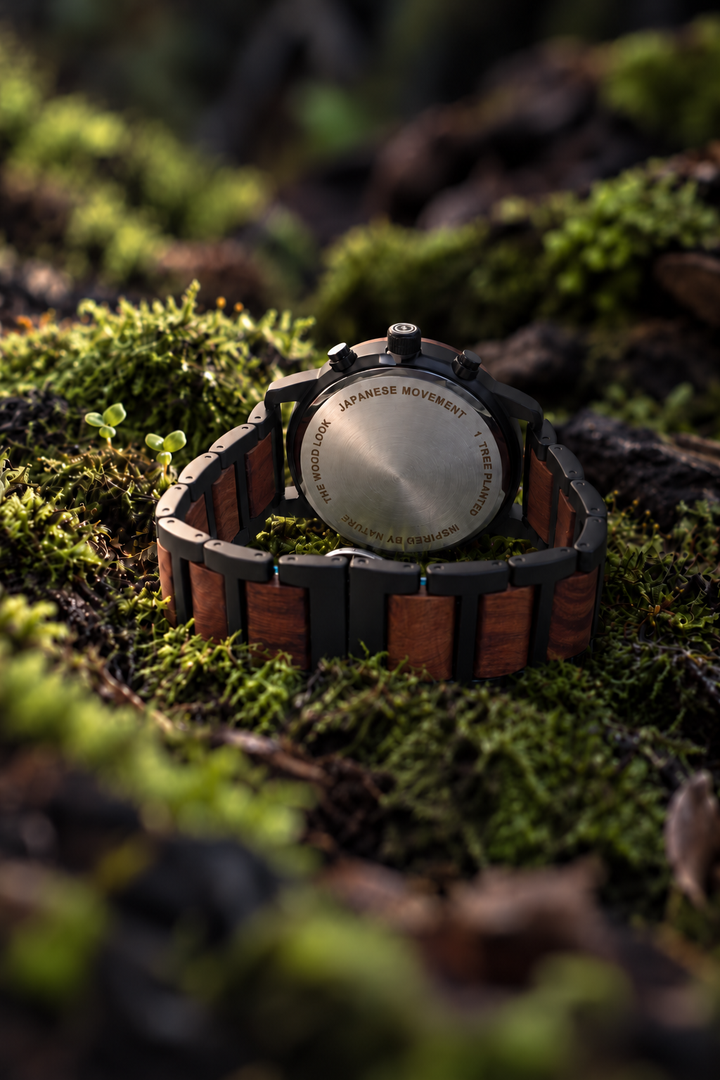 Back of the London red sandalwood watch showing the steel caseback and black steel and wood links, resting on moss