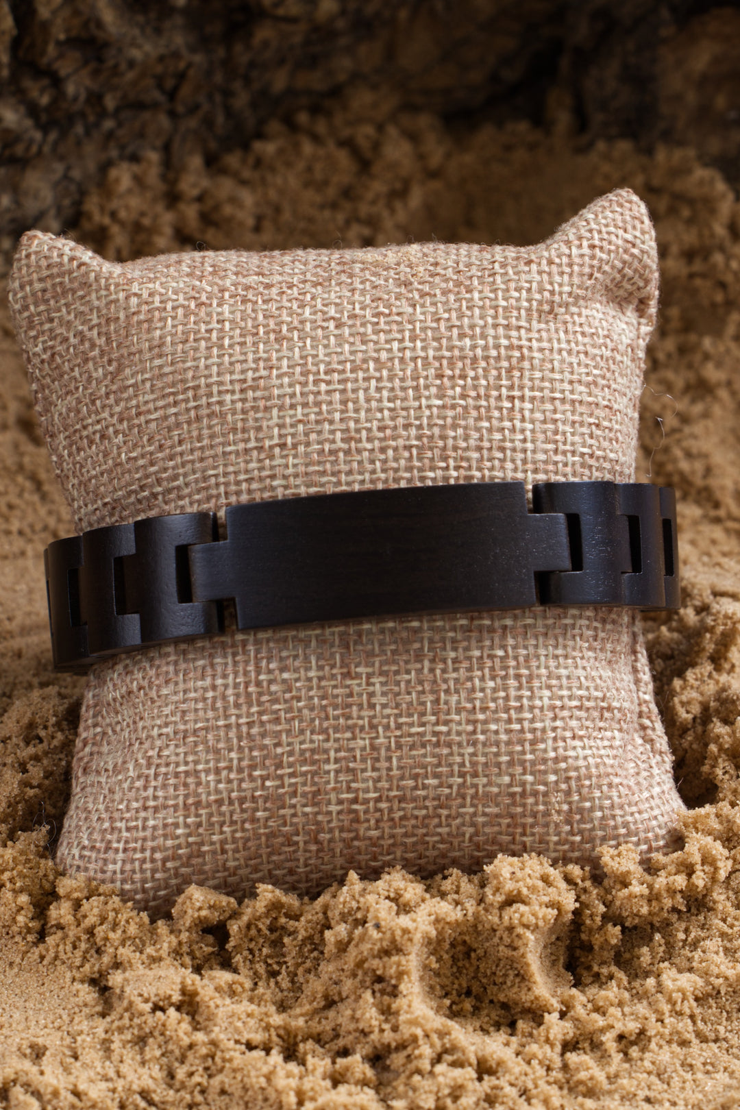 Close-up of the Nile dark ebony wooden bracelet on a cushion - The Wood Look