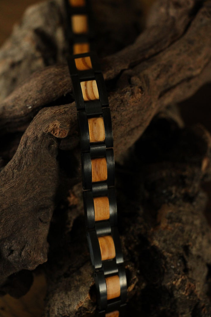 Close-up of the Paracas olive wood and black steel links on driftwood - The Wood Look